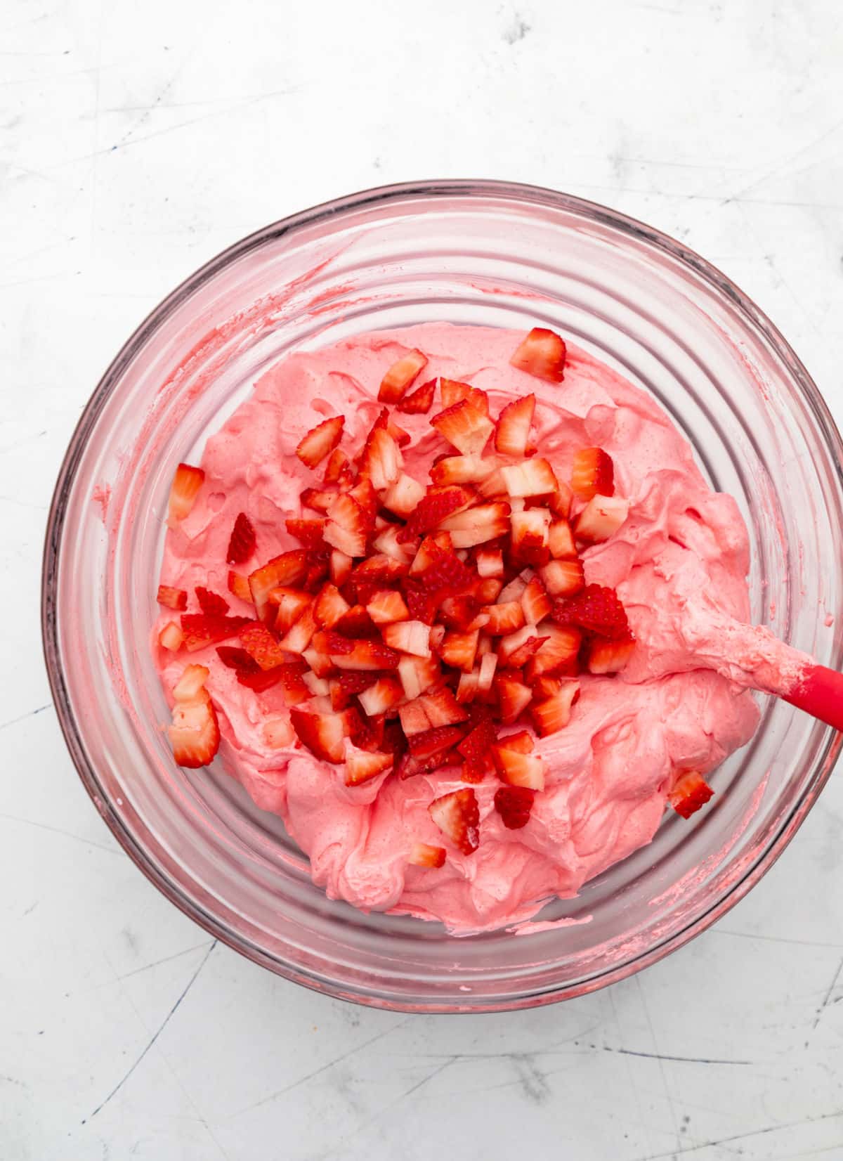 Diced strawberries on top of strawberry marshmallow mixture. 