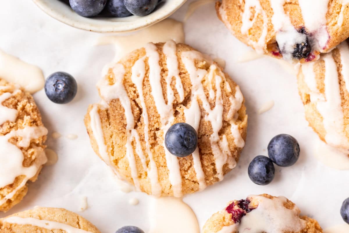 Blueberry muffin cookies next to a dish of fresh blueberries. 