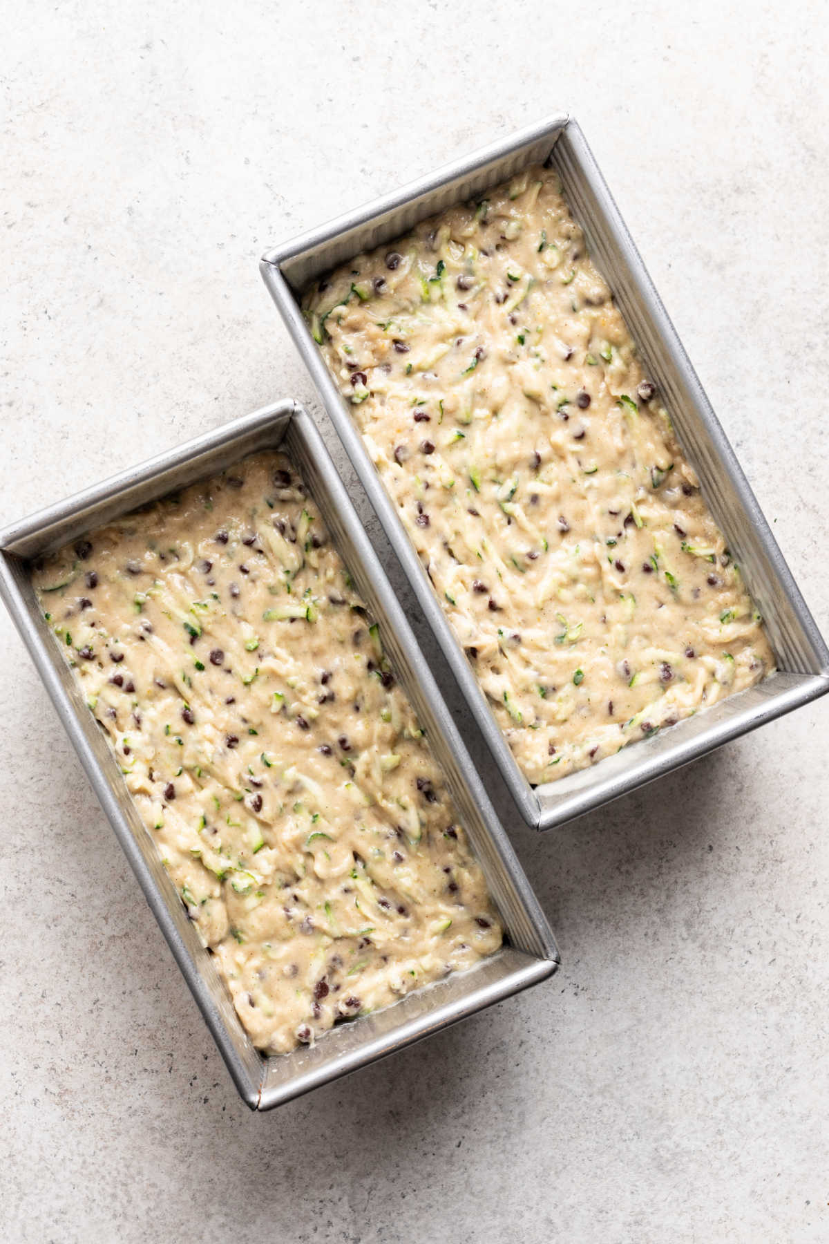 Zucchini bread batter divided into two bread pans. 