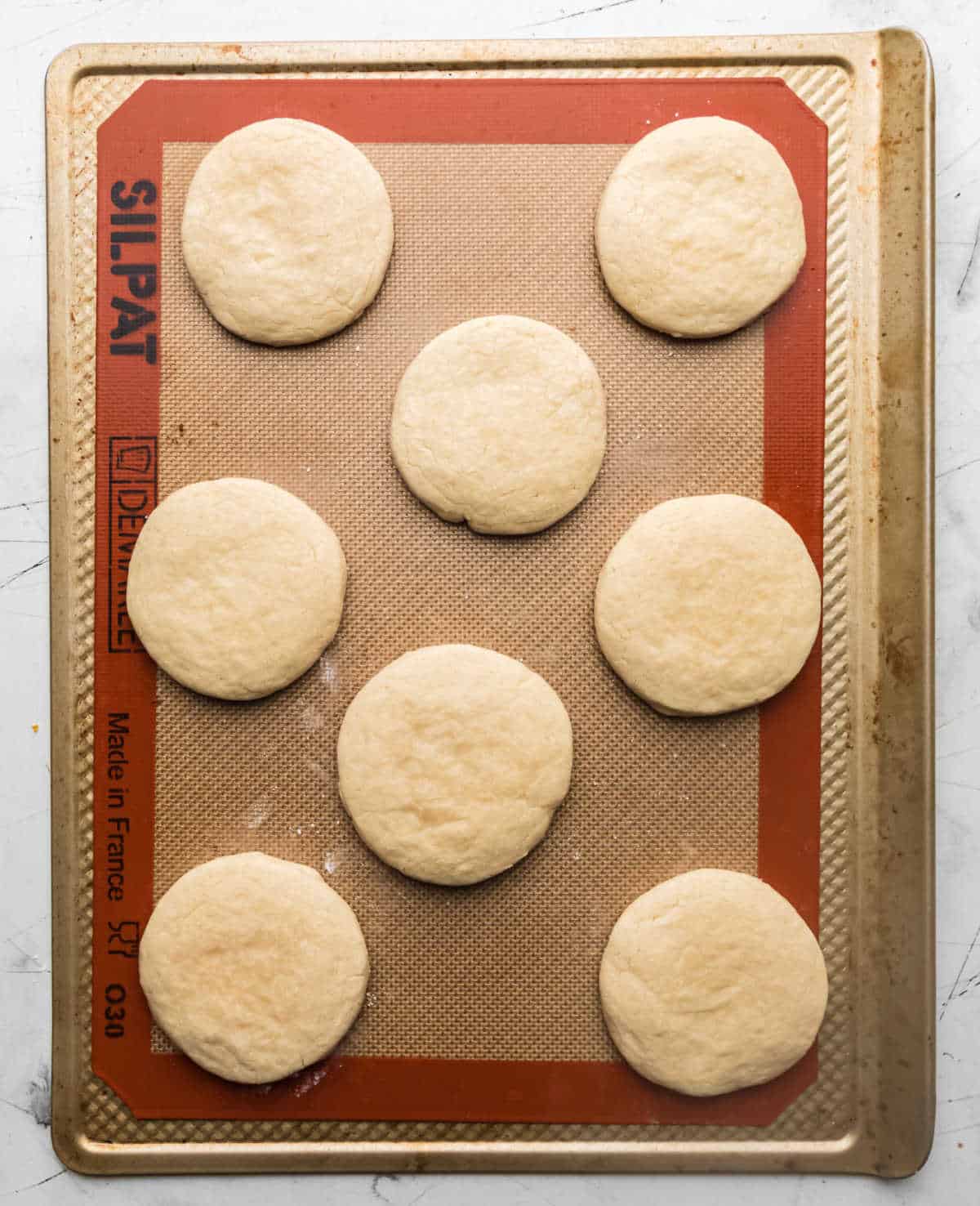 Baked sugar cookies on a baking mat.