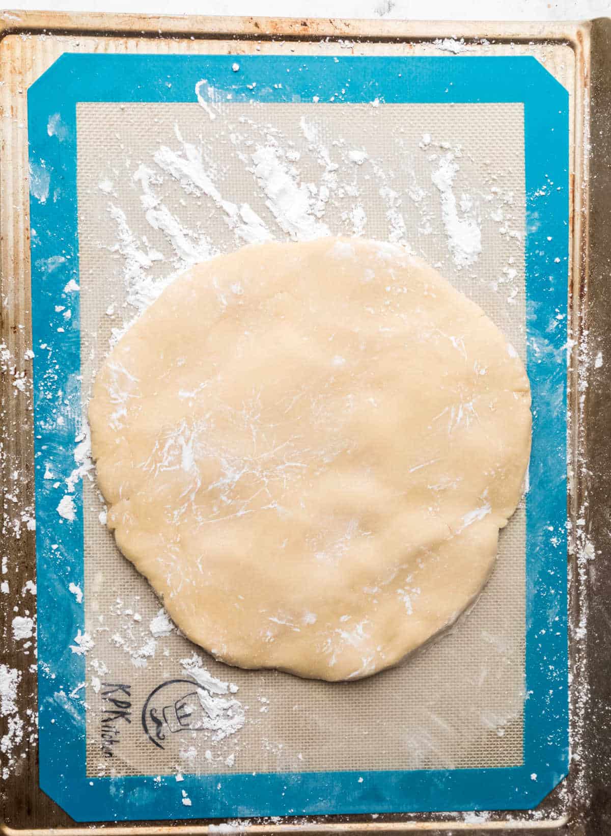 Sugar cookie dough rolled out on a silicone baking mat.