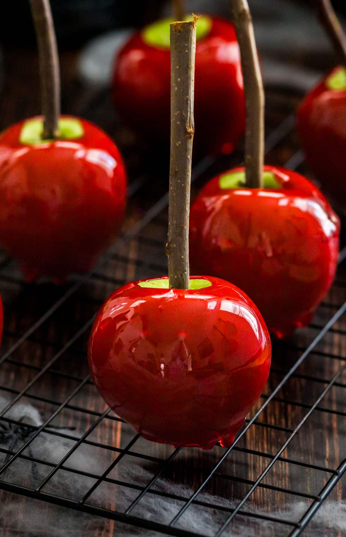 Four candy apples with stick stems. 