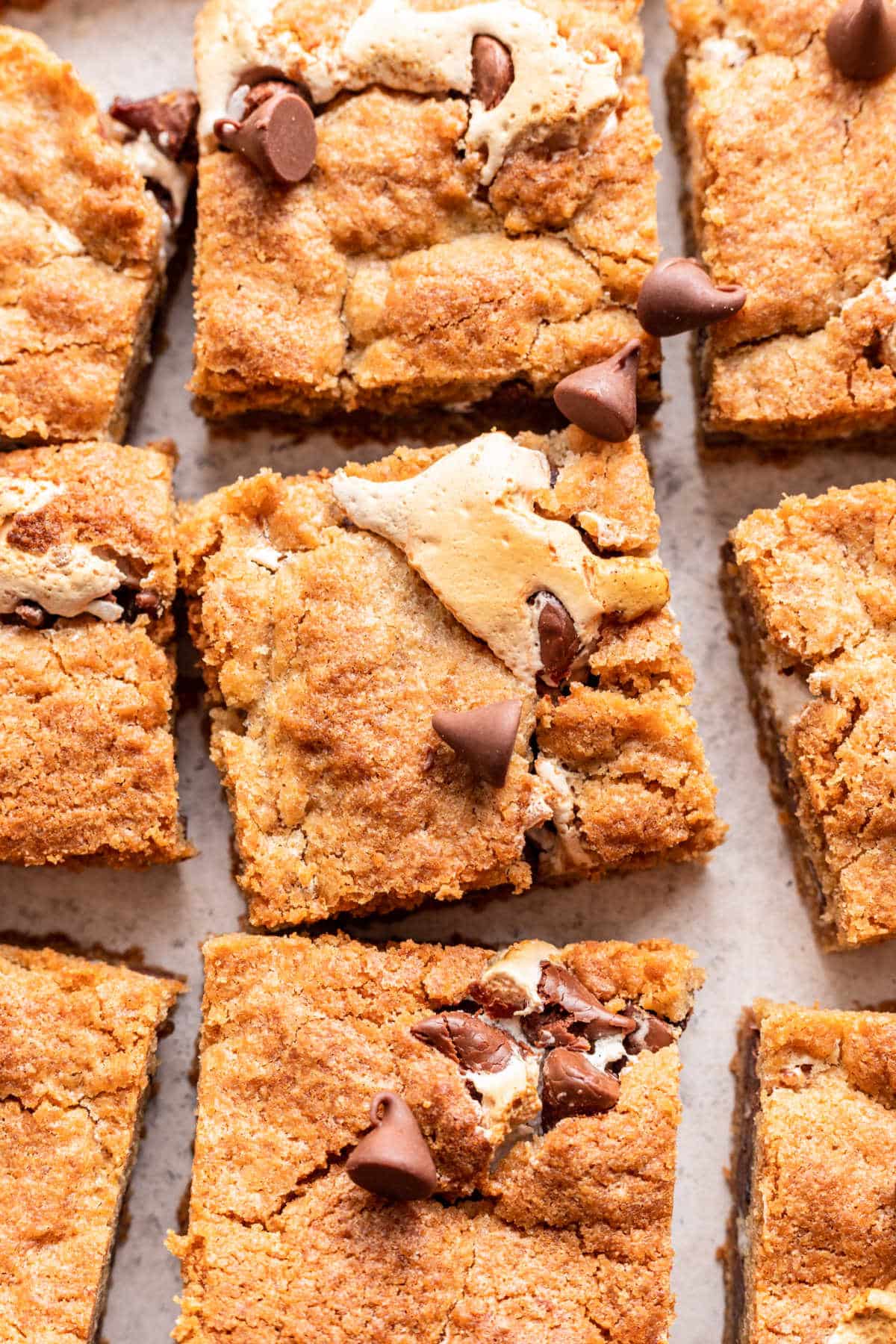 A row of s'mores bars on a piece of white parchment paper.