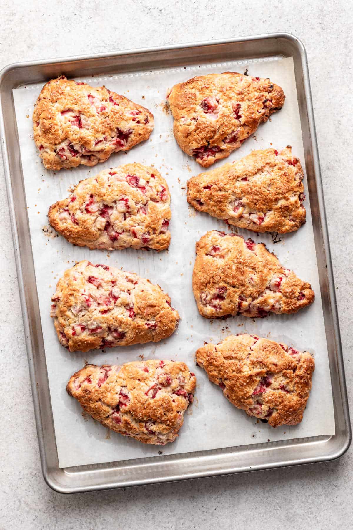 Baked strawberry scones on a baking tray.