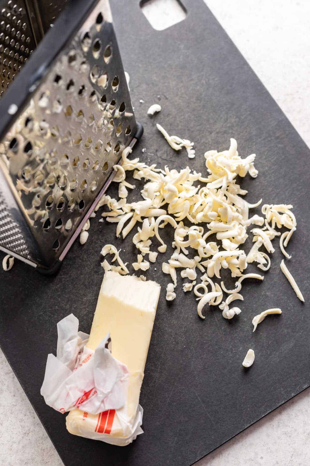 Grated frozen butter next to a grater. 