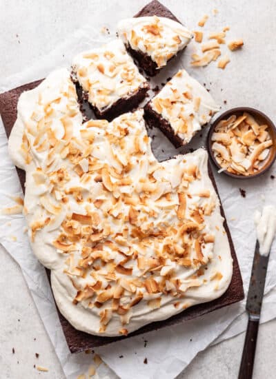 Chocolate coconut sheet cake with three pieces cut.