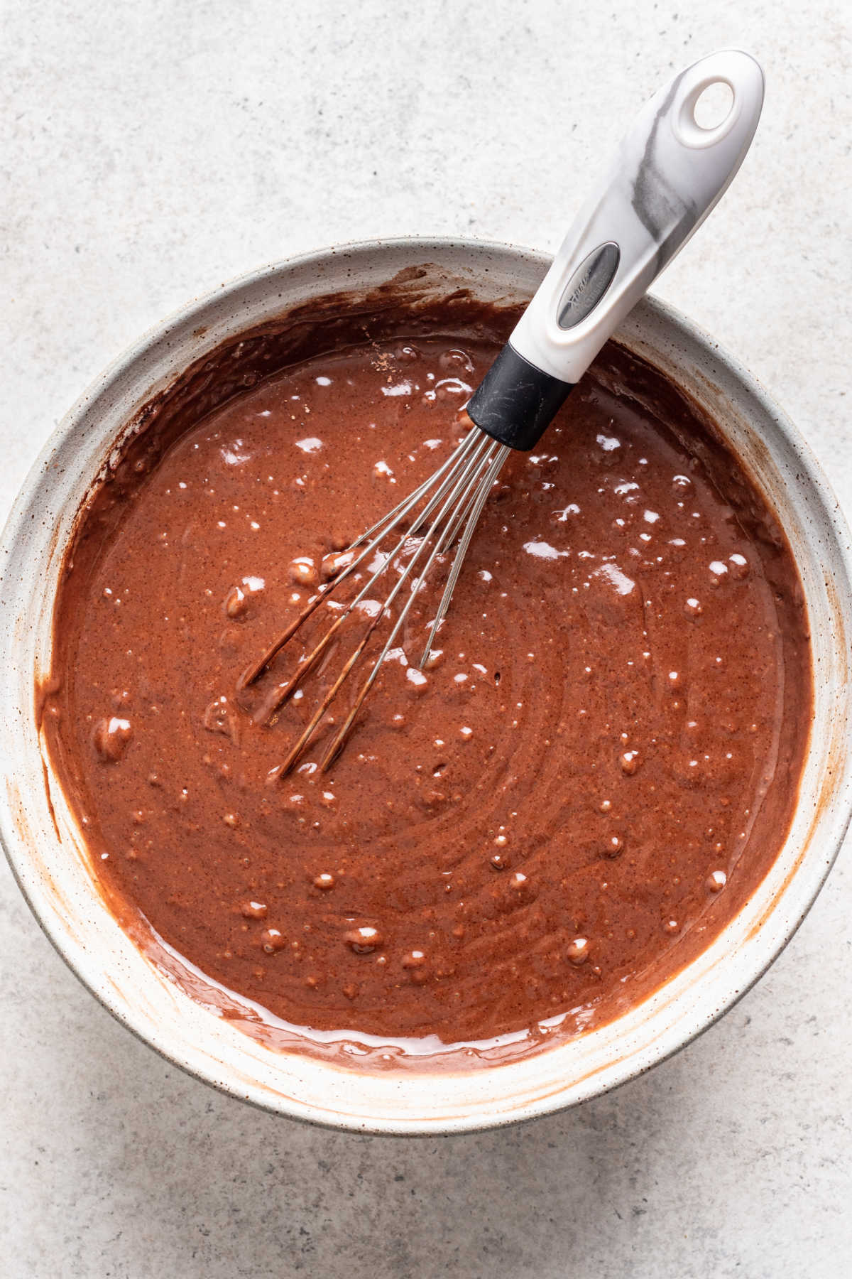 Ingrédients humides mélangés aux ingrédients secs pour le gâteau au chocolat et à la noix de coco.