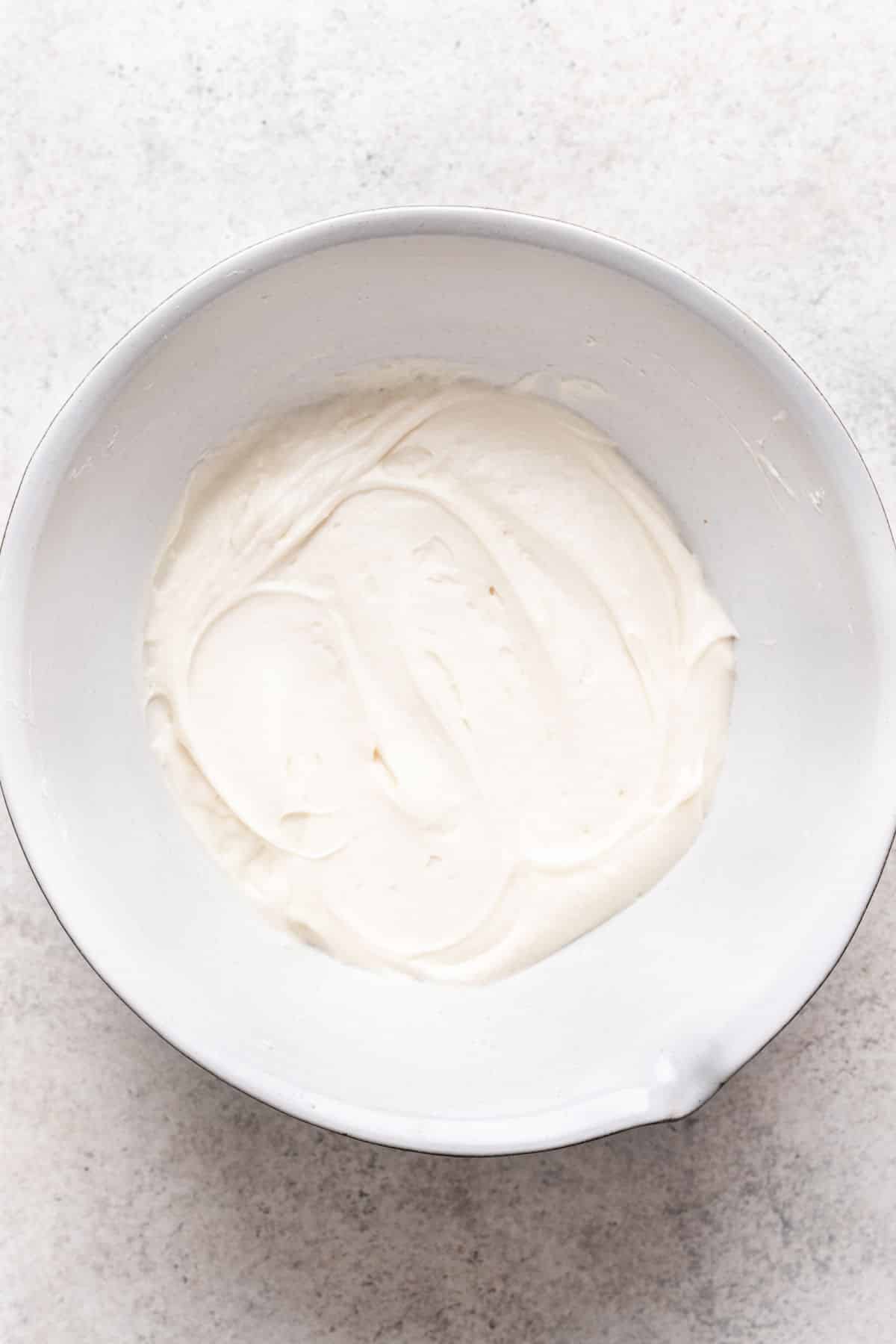 Coconut buttercream in a white mixing bowl. 