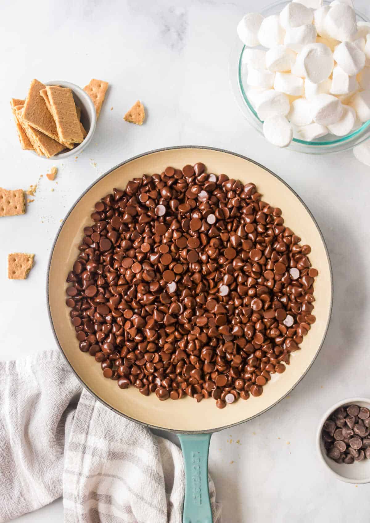 Chocolate chips in an even layer in a cast iron skillet. 