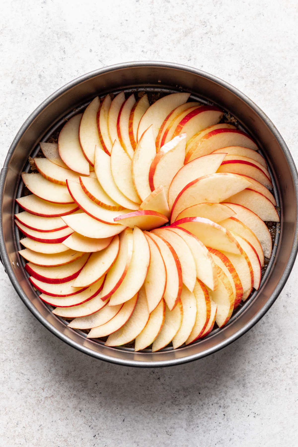 Tranches de pommes en cercle concentrique dans un moule.