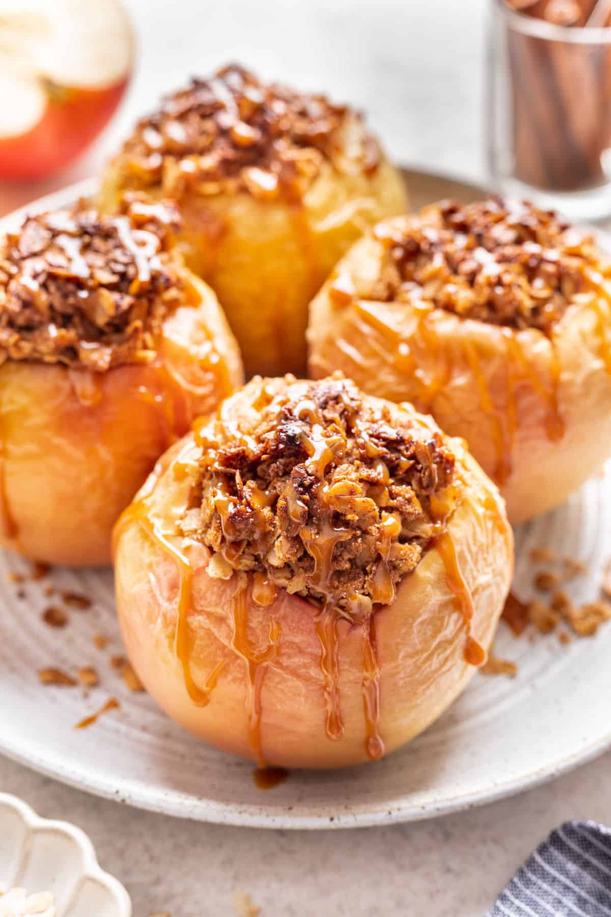 Baked apples drizzled with caramel on a white plate. 