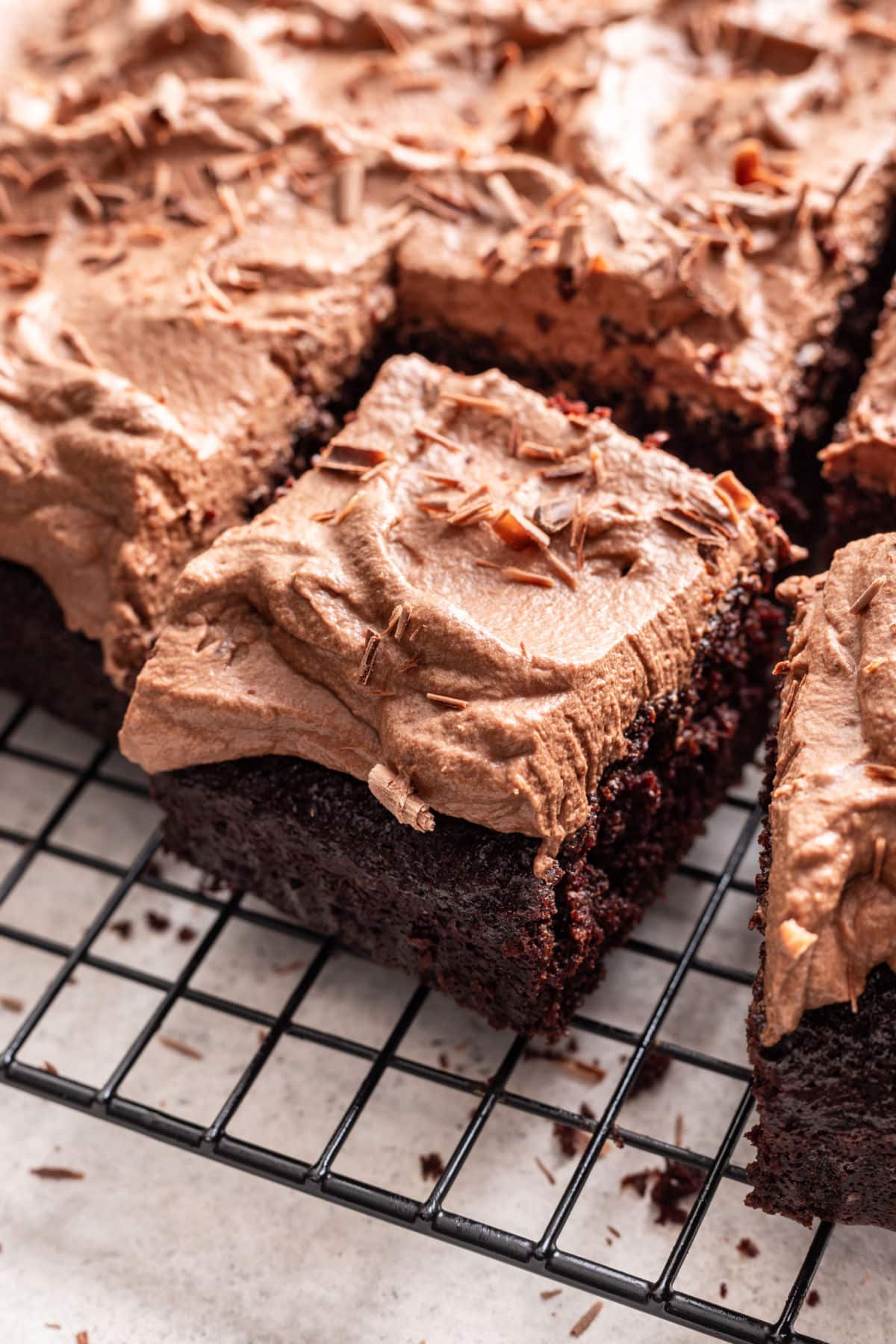 Close up photo of a slice of chocolate mousse cake next to the cake. 