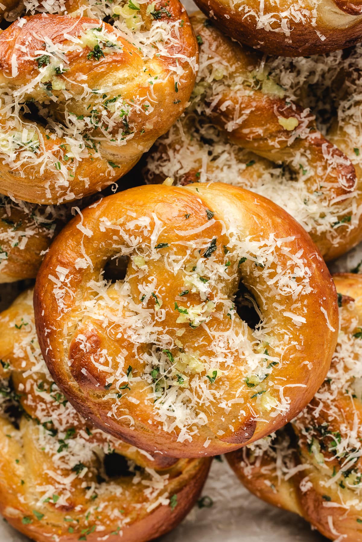 Garlic parmesan pretzels stacked overlapping on top of each other.