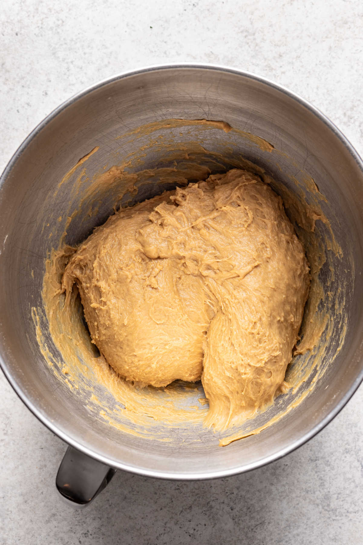 Pâte à roulés à la cannelle dans un bol de mélange en métal.