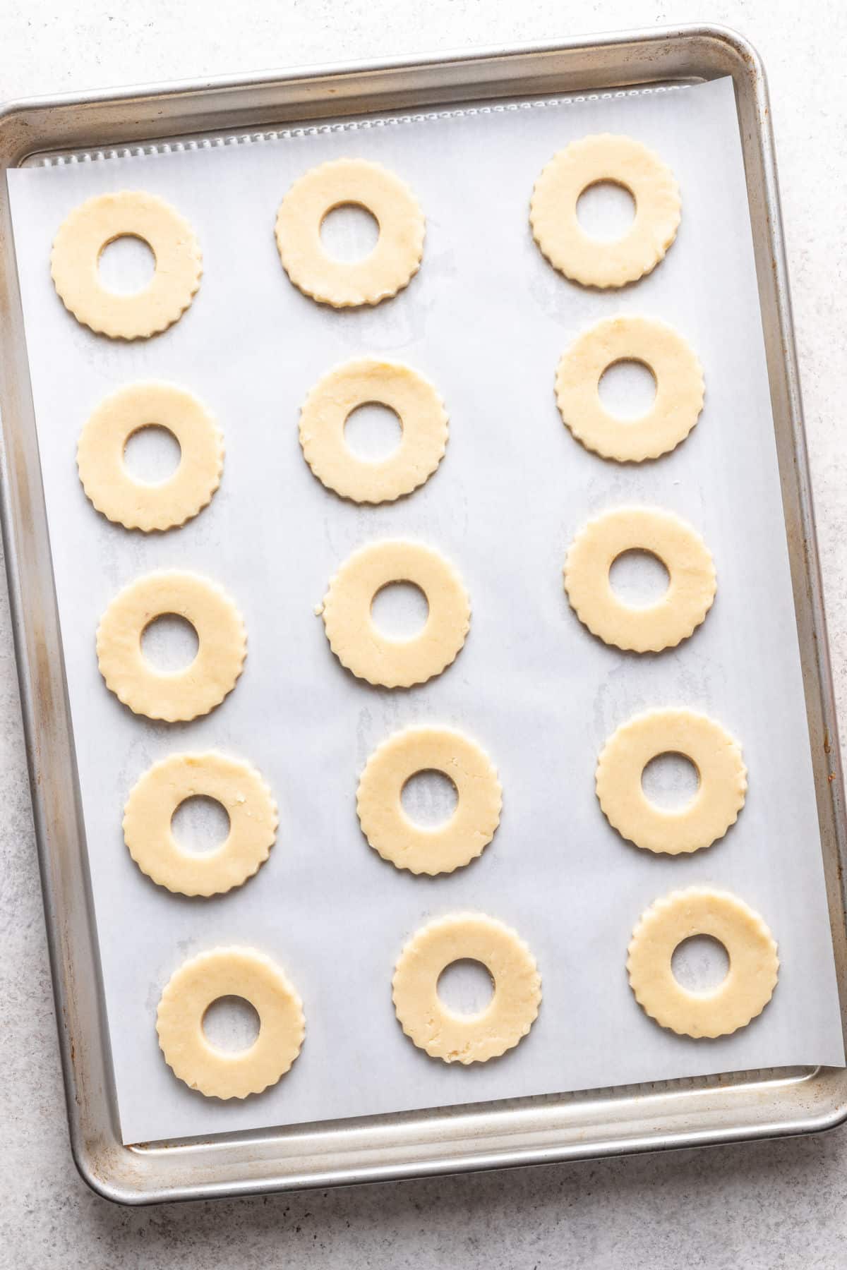 Cercles de pâte à biscuits Linzer avec un trou découpé au centre.