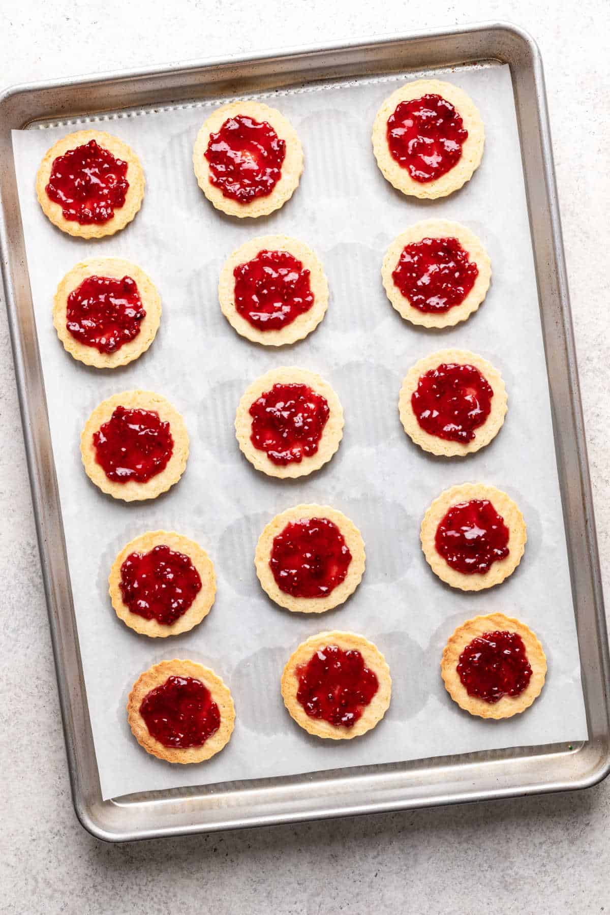 Baked linzer cookies topped with raspberry jam.