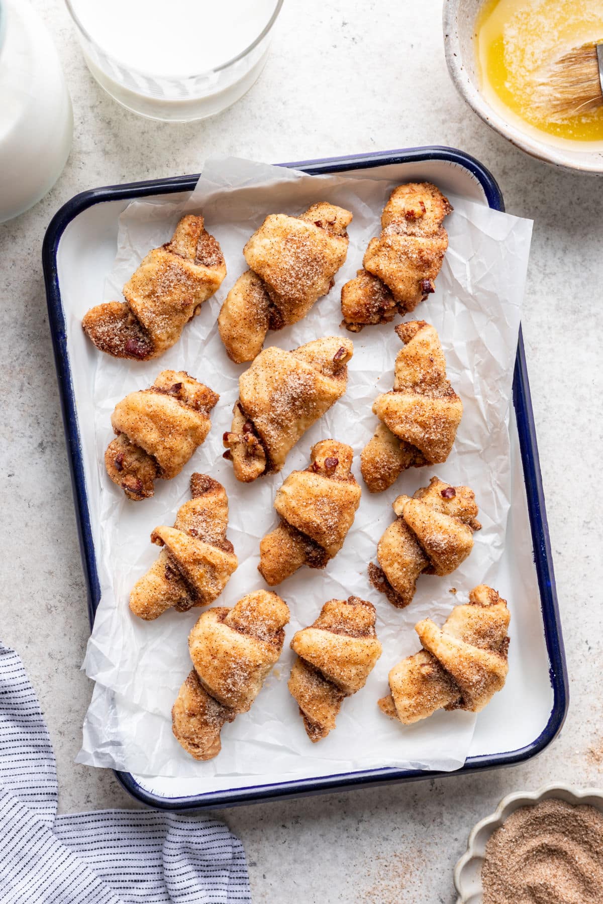 Rugelach au sucre de cannelle dans un plat tapissé de papier sulfurisé.