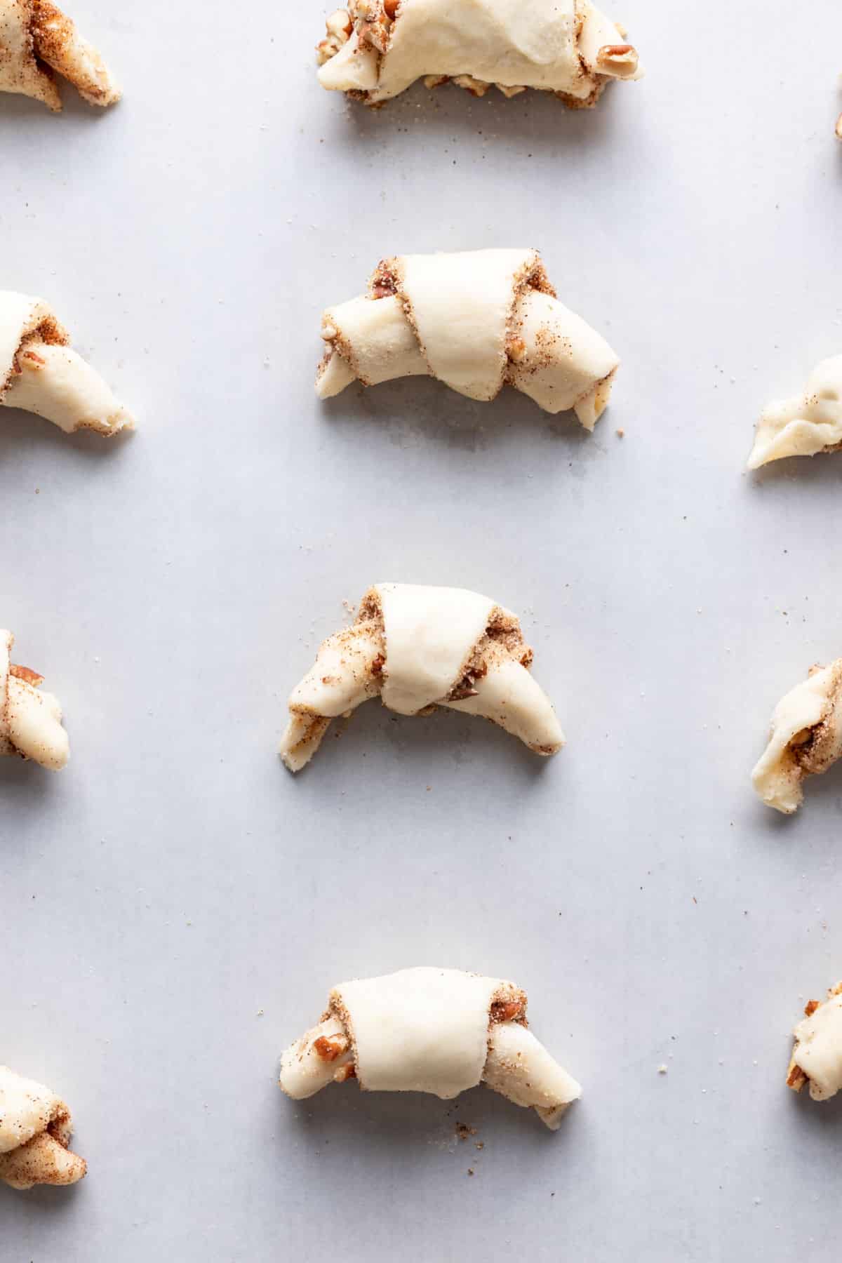 Rugelach enroulés sur un morceau de papier sulfurisé.