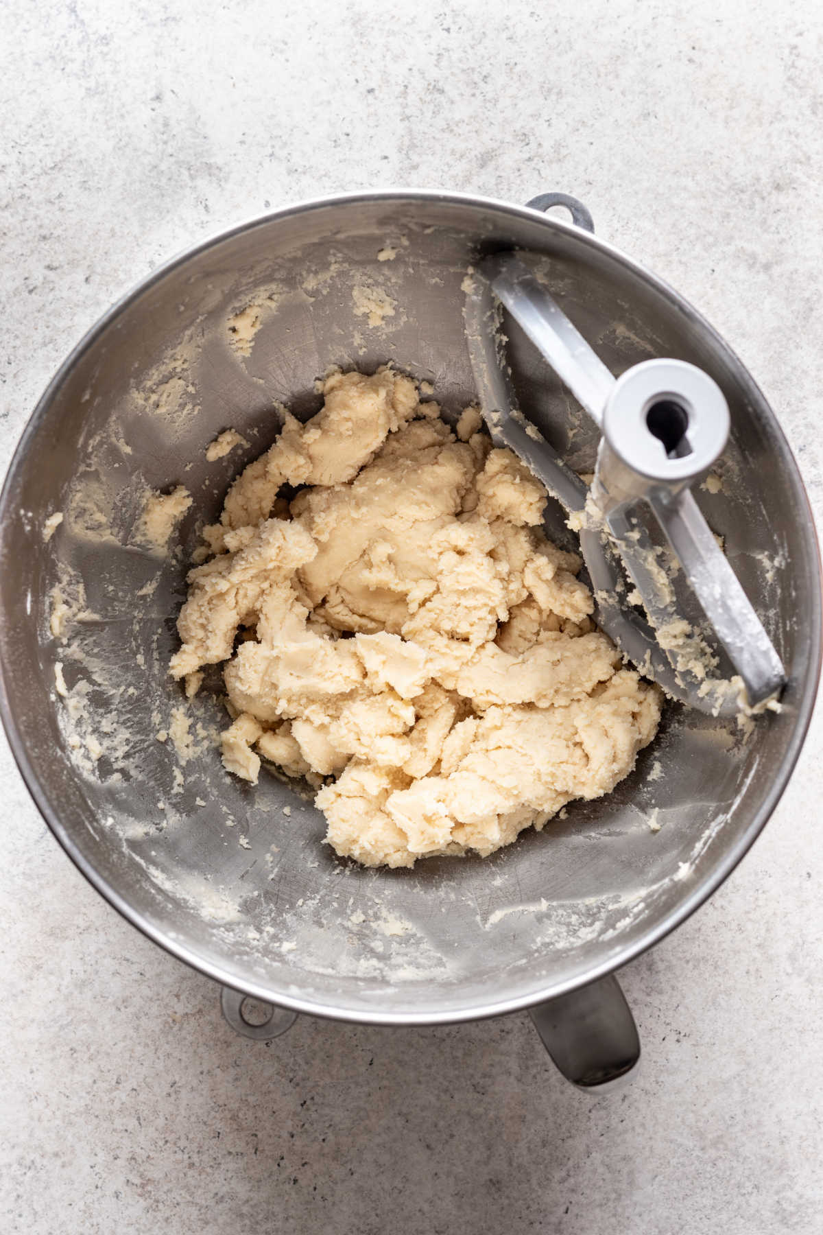 Whipped shortbread cookies dough in a silver mixing bowl. 