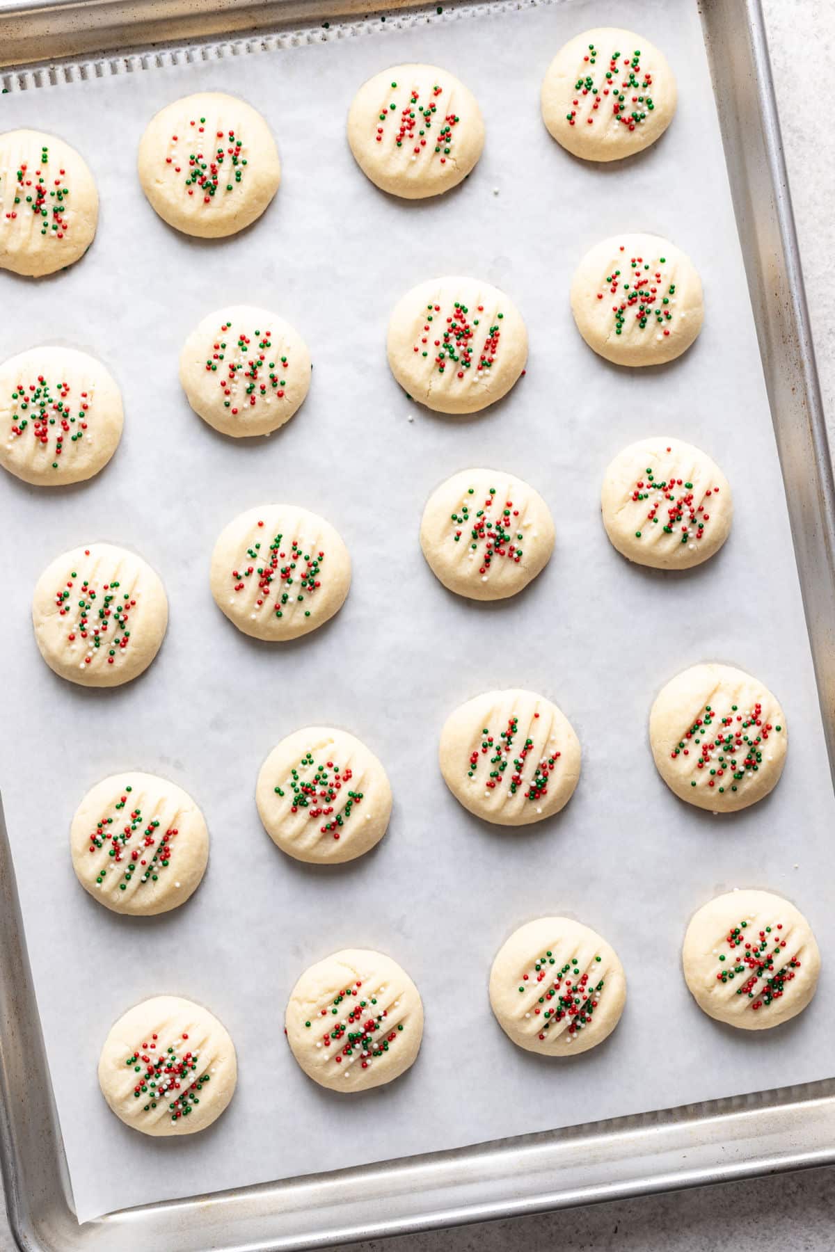 Baked whipped shortbread cookies on a baking sheet. 