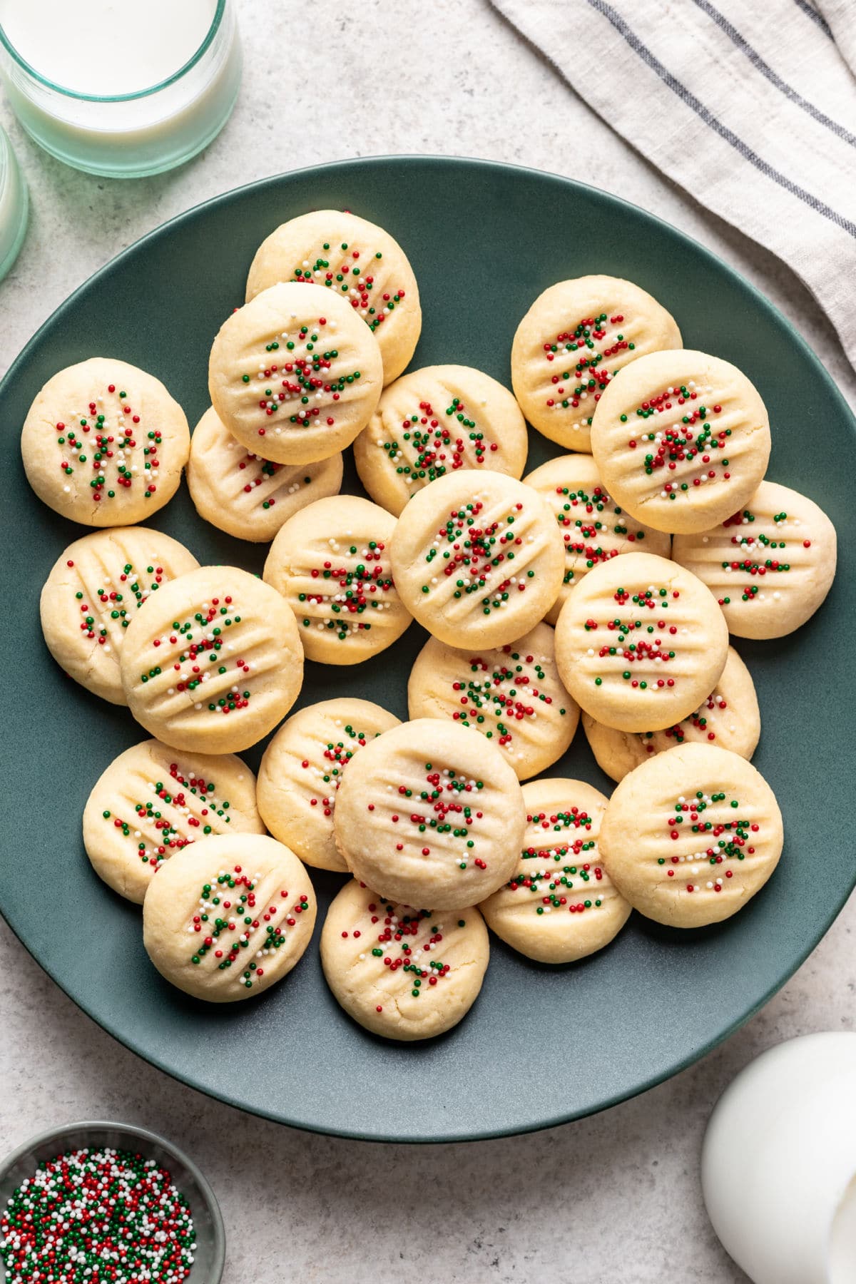 Whipped shortbread cookies on a teal plate. 