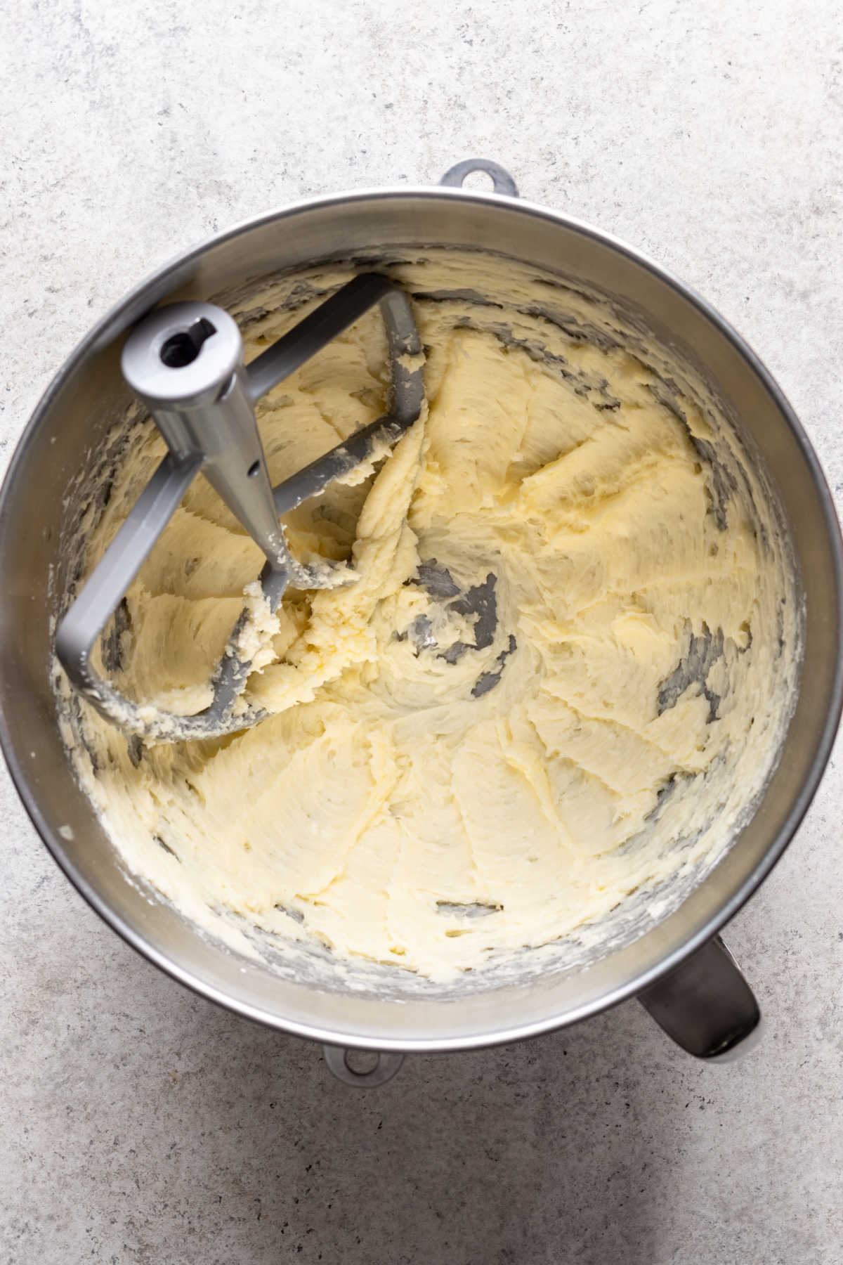 Butter and powdered sugar creamed in a silver mixing bowl. 