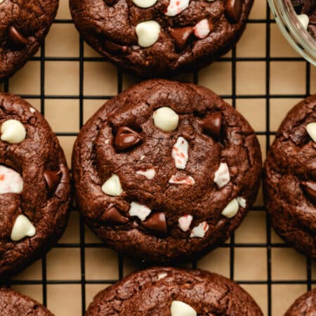 Rows of peppermint bark cookies on a black wire cooling rack.