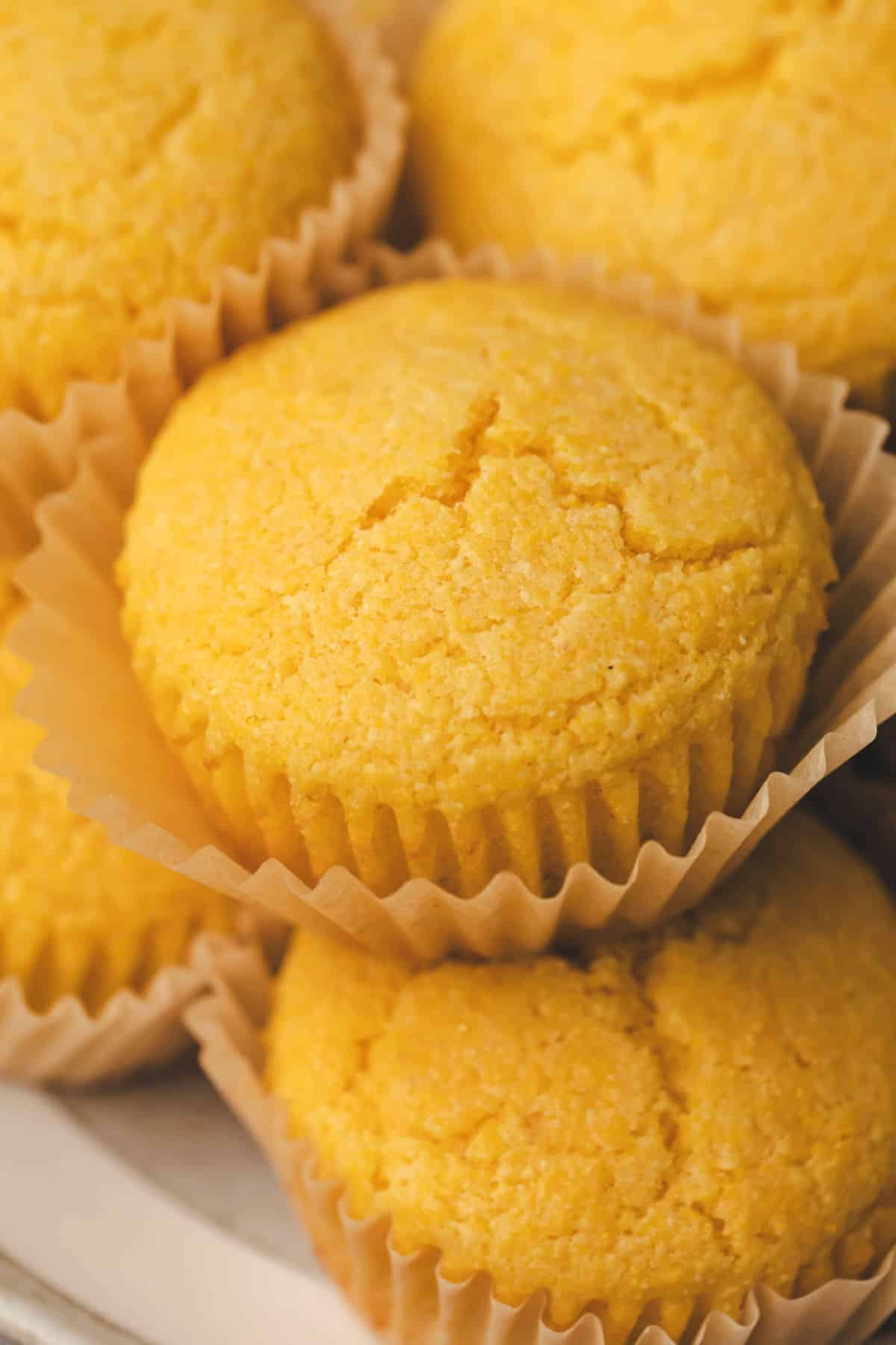 Close up photo of a honey cornbread muffin on top of another muffin. 