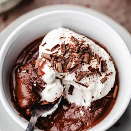 A dish of homemade chocolate pudding with a spoon taking a bite.