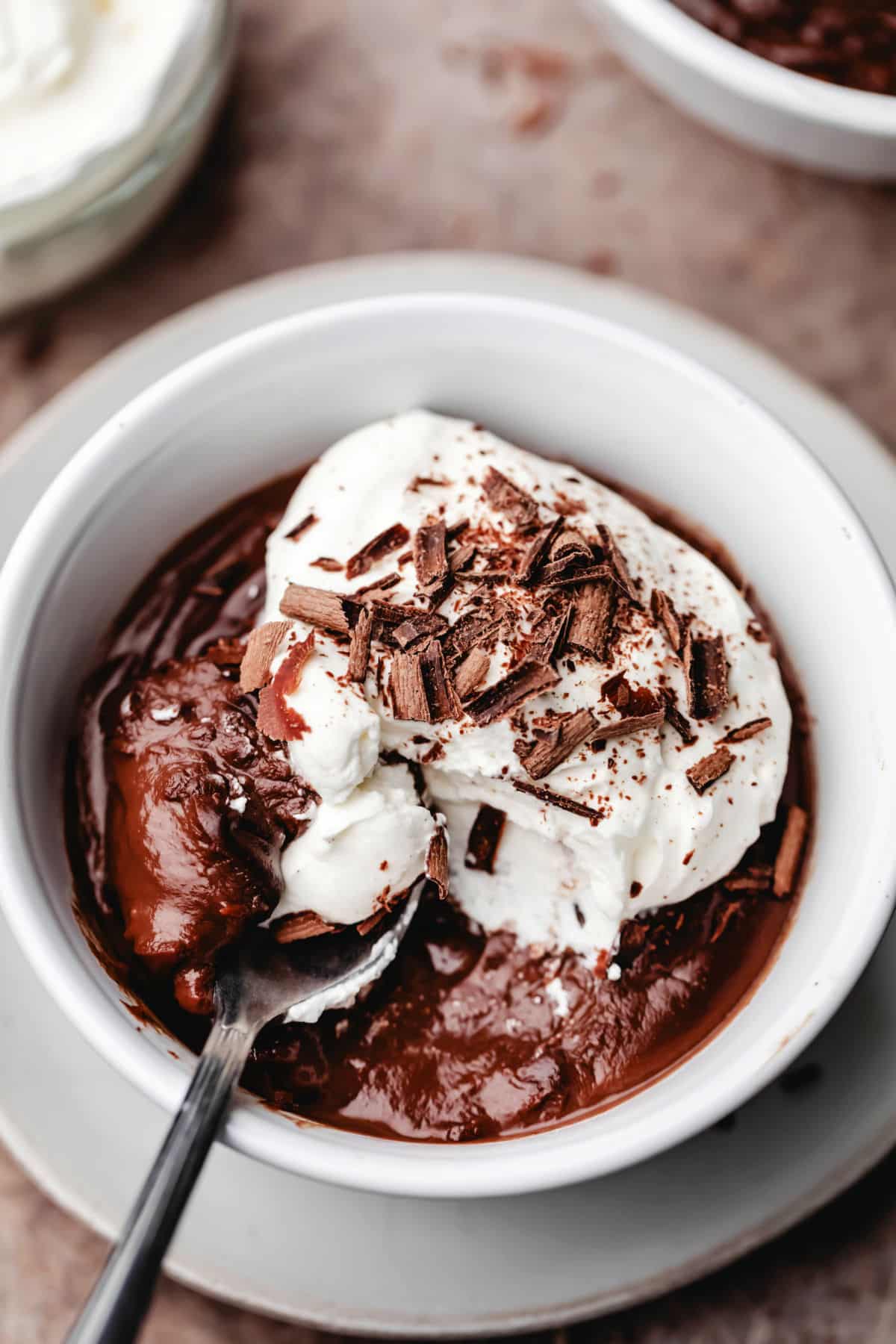 A dish of homemade chocolate pudding with a spoon taking a bite. 