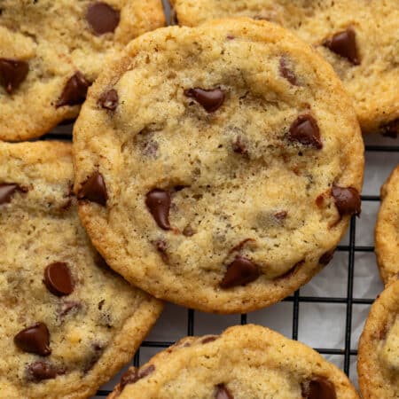 Overlapping eggless chocolate chip cookies on a wire cooling rack.