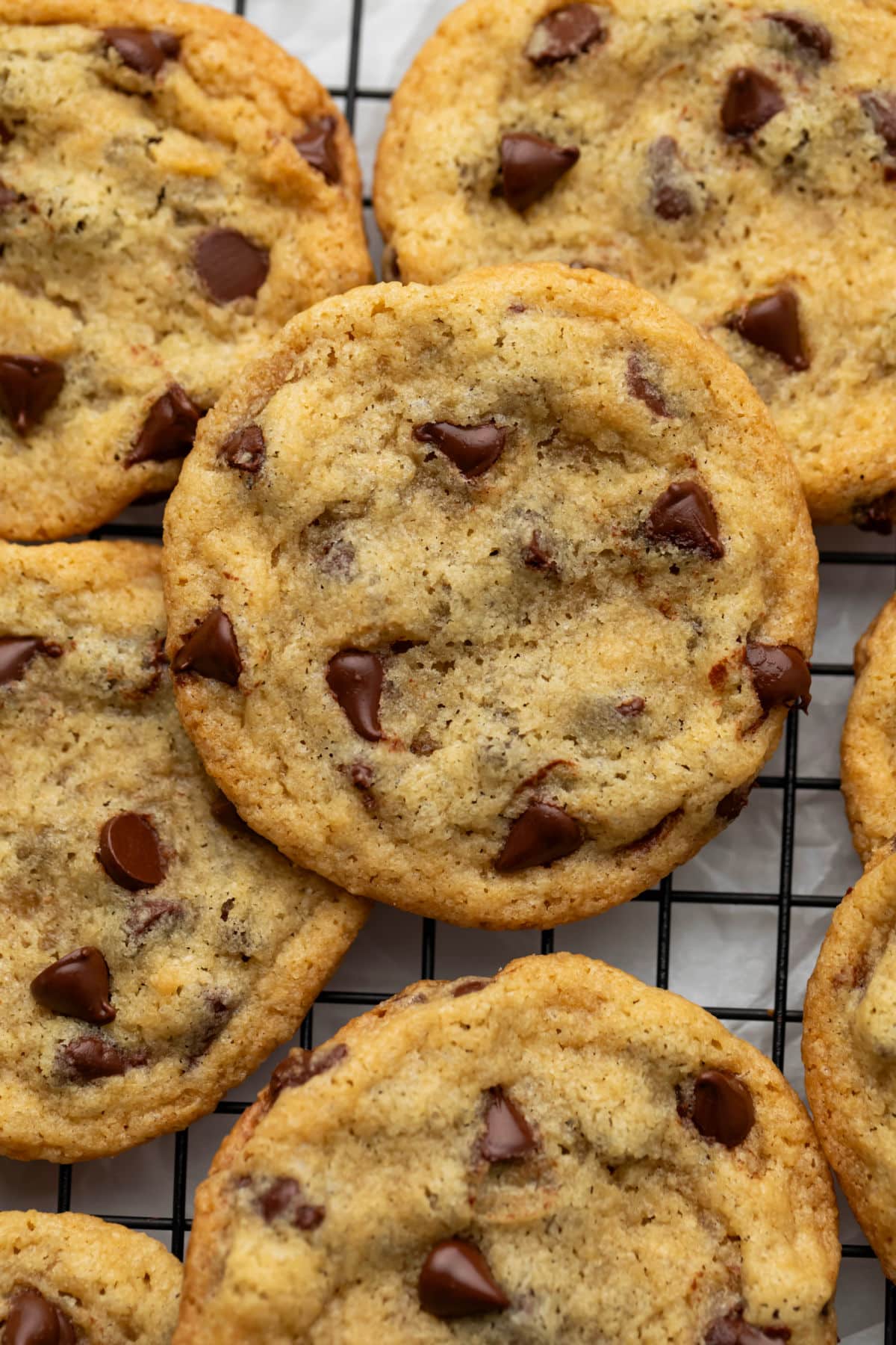 Overlapping eggless chocolate chip cookies on a wire cooling rack. 