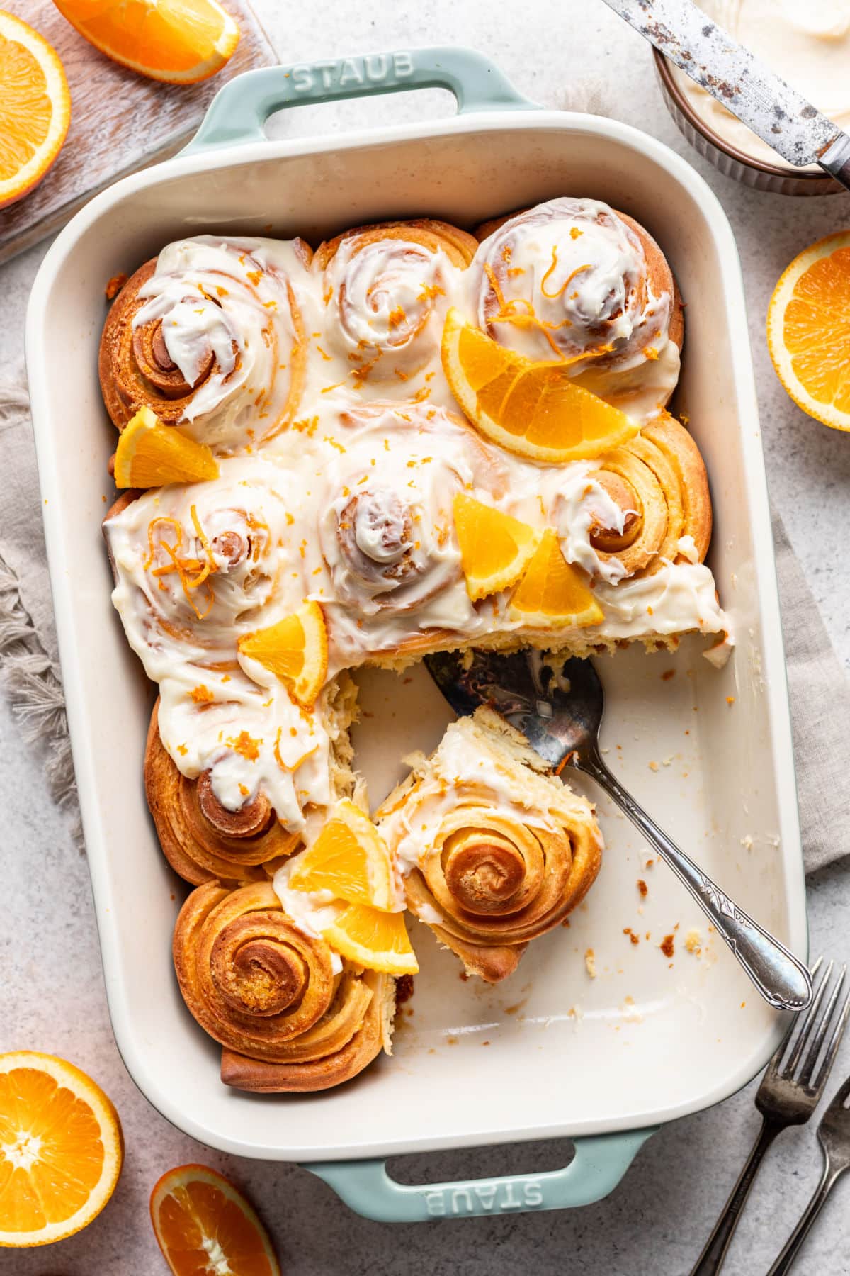 Brioches à l'orange dans un plat de cuisson avec une partie des brioches retirées.